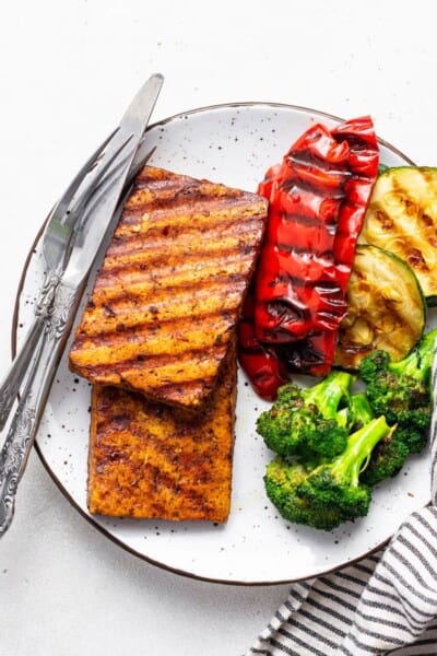plate with grilled marinated tofu steaks, peppers, zucchini and broccoli