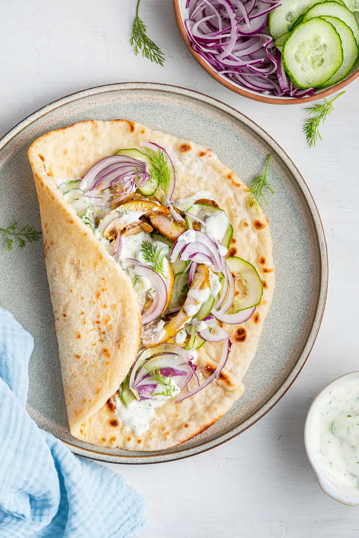 Overhead view of chicken shawarma gyro on plate, with one end folded