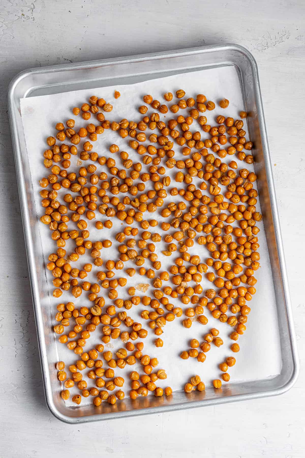 A bunch of roasted chickpeas on a baking sheet