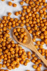 A counter full of crispy chickpeas, with a wooden spoon in the middle with chickpeas