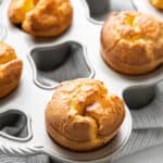Close up of a gluten-free popover still in the popover pan, with other popovers in the pan in the background