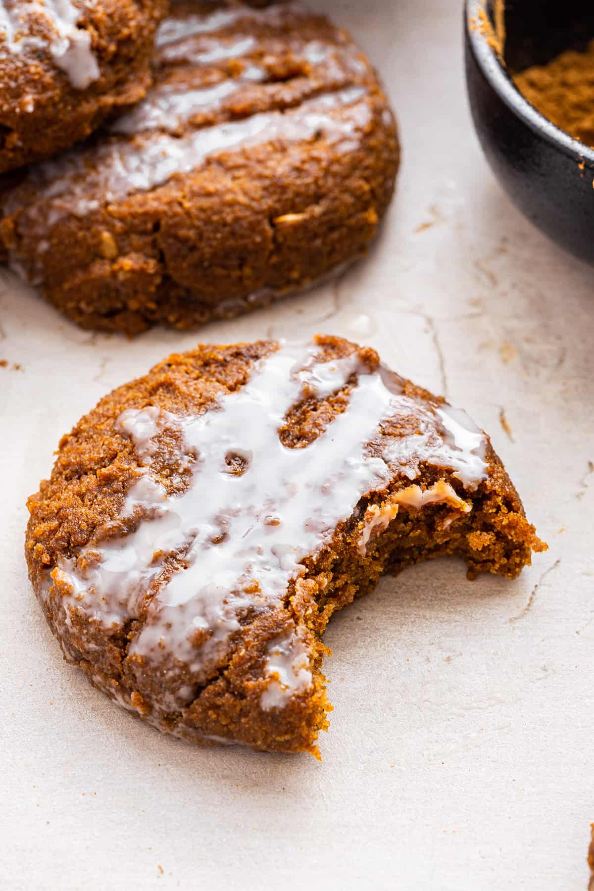 Closeup of frosted healthy pumpkin cookie with bite taken out