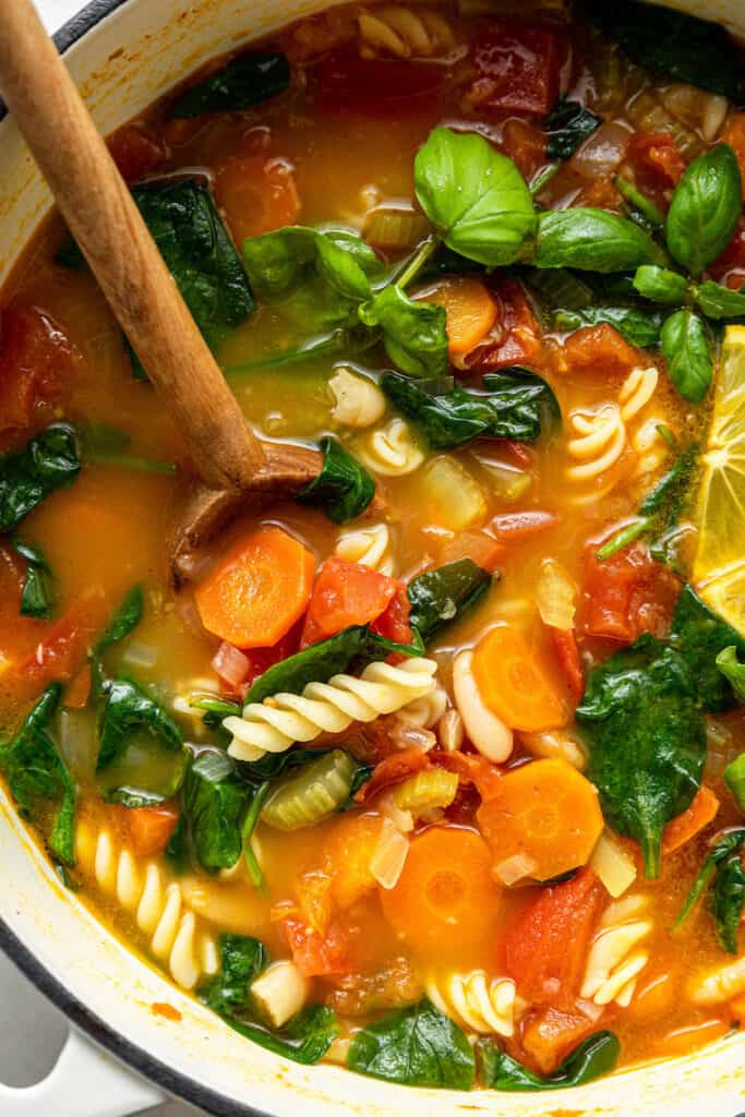 pot of pasta and vegetable soup with basil