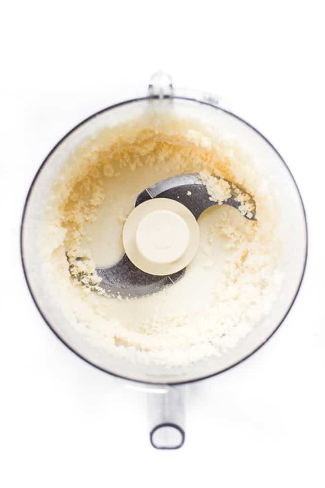 Overhead view of coconut solids and oils separating in a food processor
