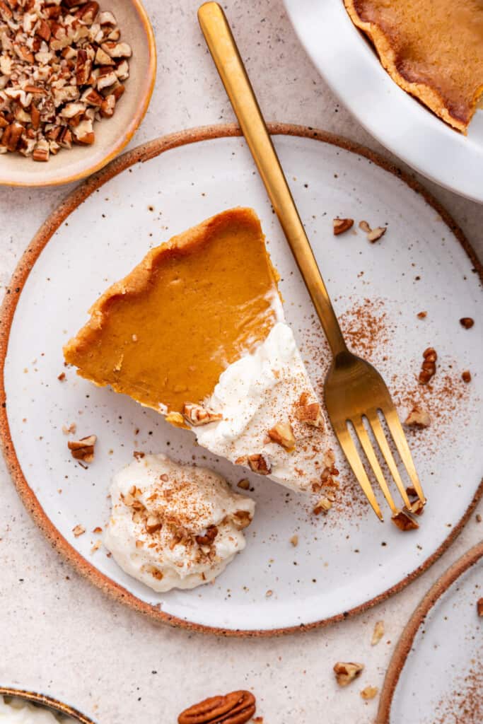 Overhead view of gluten-free pumpkin pie on plate with gold fork