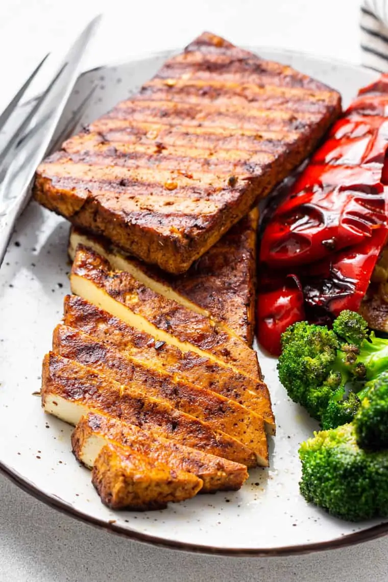 plate with two grilled tofu steaks, peppers and broccoli