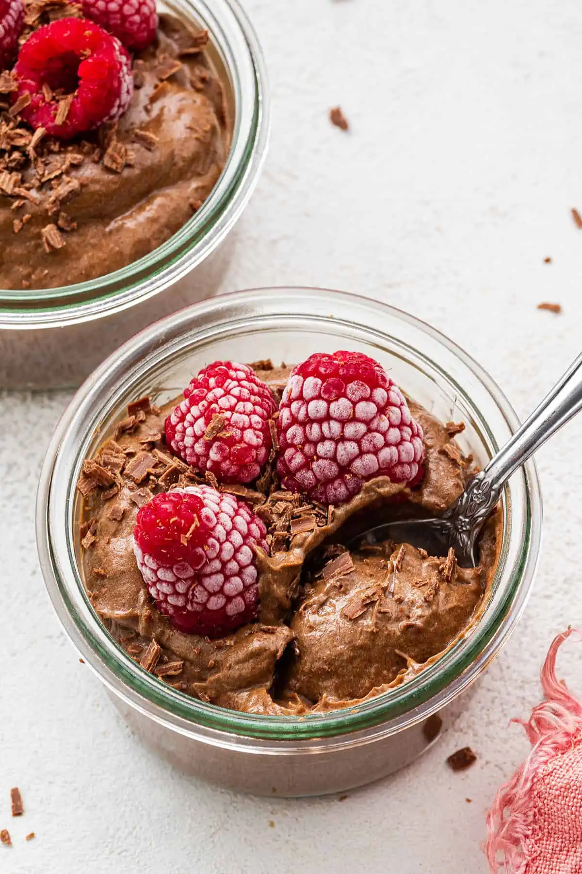 A small mason jar filled with chocolate mousse and topped with raspberries.