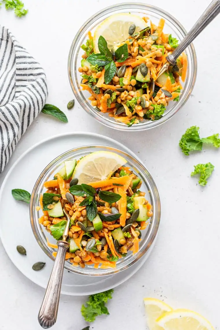 overhead view of lentil salad in glass bowls with carrots and lemon