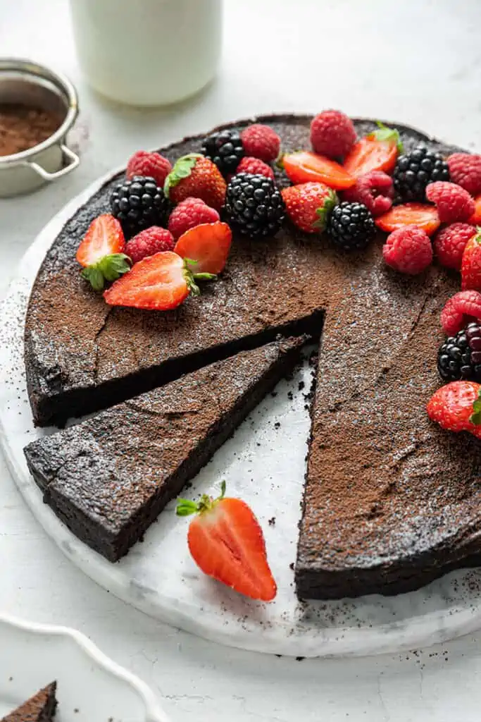 A flourless dark chocolate cake with a slice removed