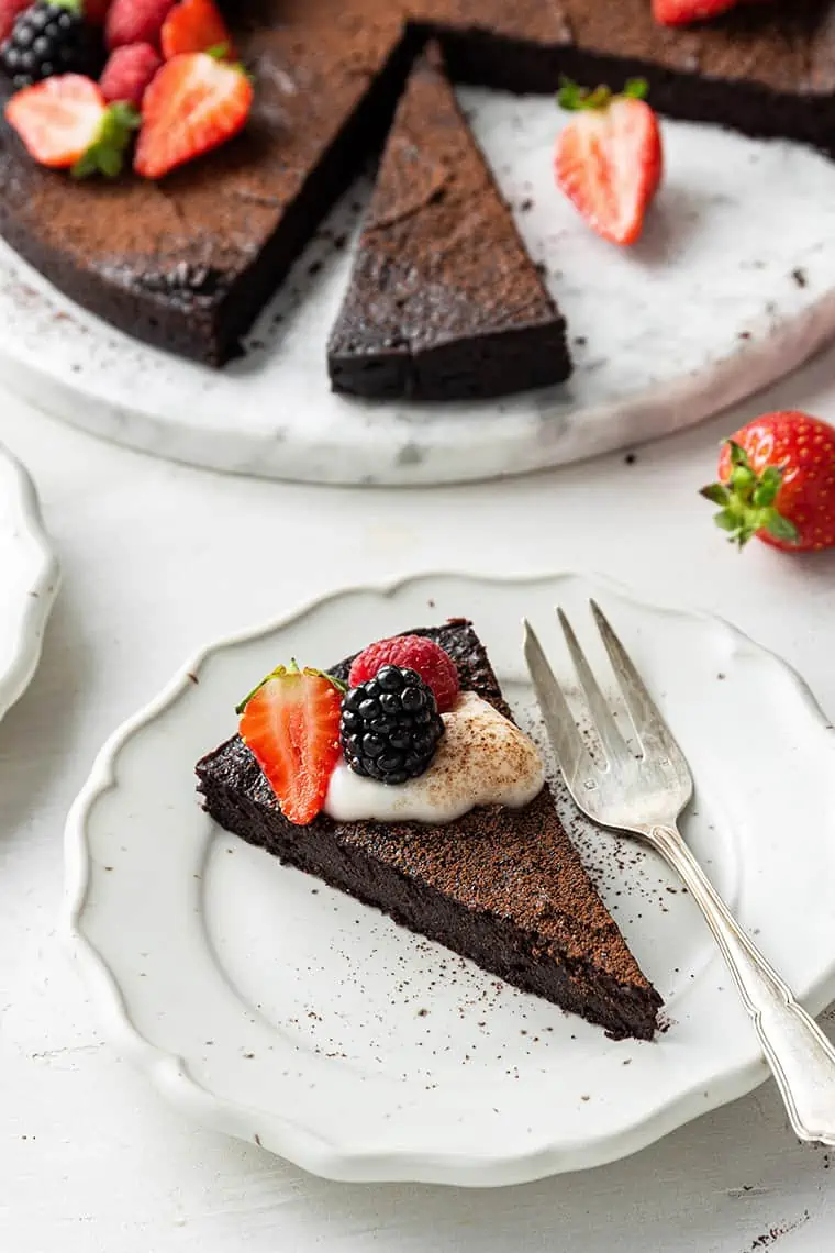 A slice of flourless dark chocolate cake on a plate