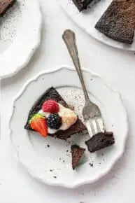 Aerial view of a bite of flourless dark chocolate cake on a fork