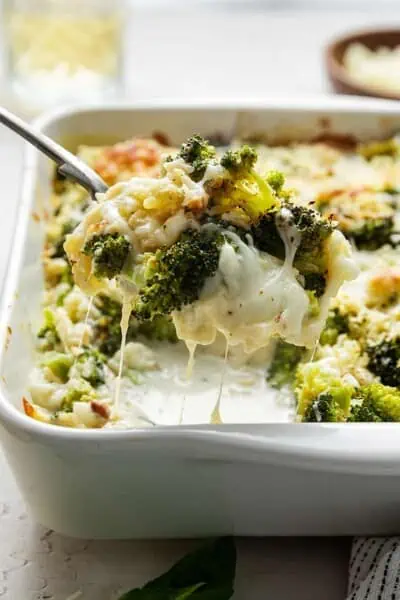 Broccoli casserole being spooned out of a baking dish